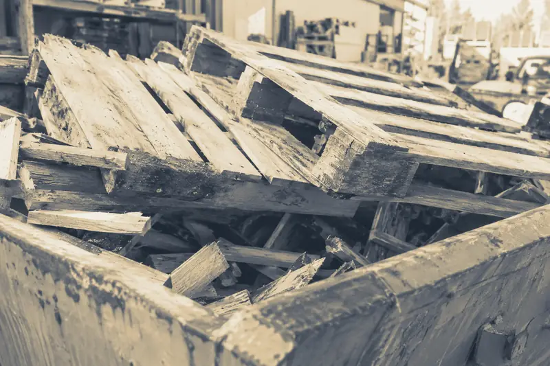 Palettes cassées et chutes de bois dans une benne, image d’illustration